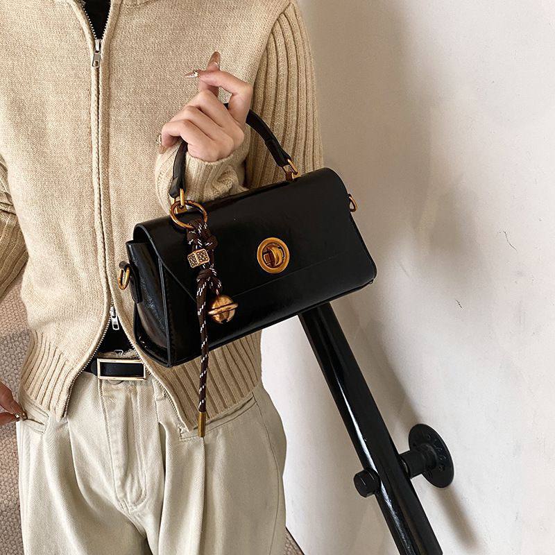 Structured black top-handle satchel or crossbody bag