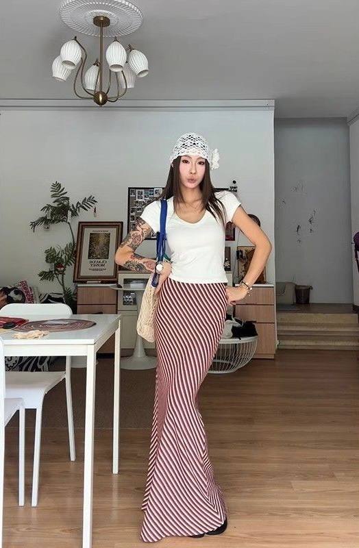 White t-shirt paired with a brown or burgundy and white striped mermaid maxi skirt