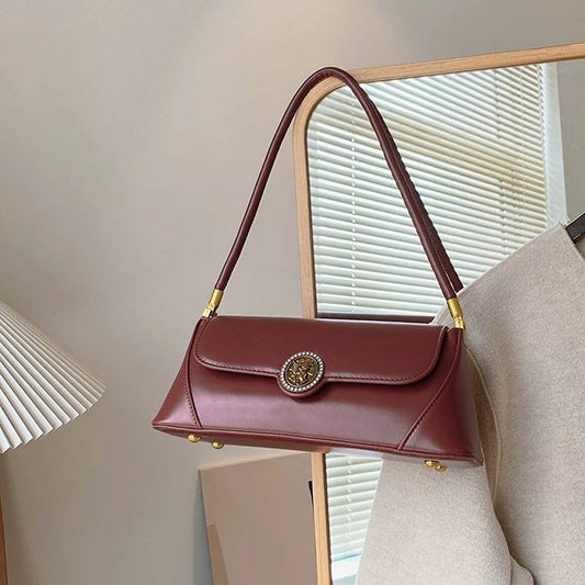 Burgundy underarm bag features a vintage bag