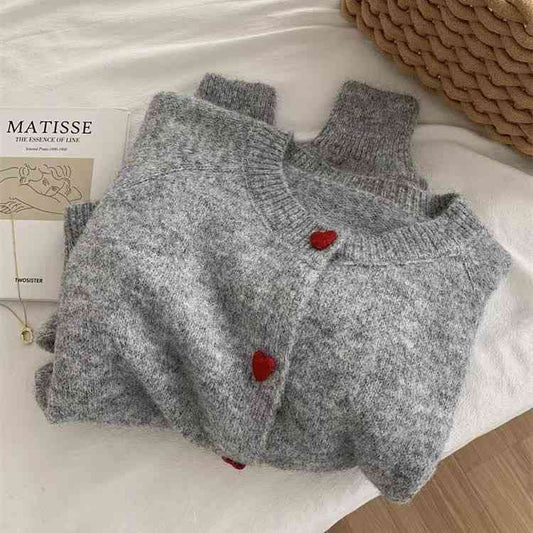 Women's grey knit cardigan featuring red heart shaped buttons