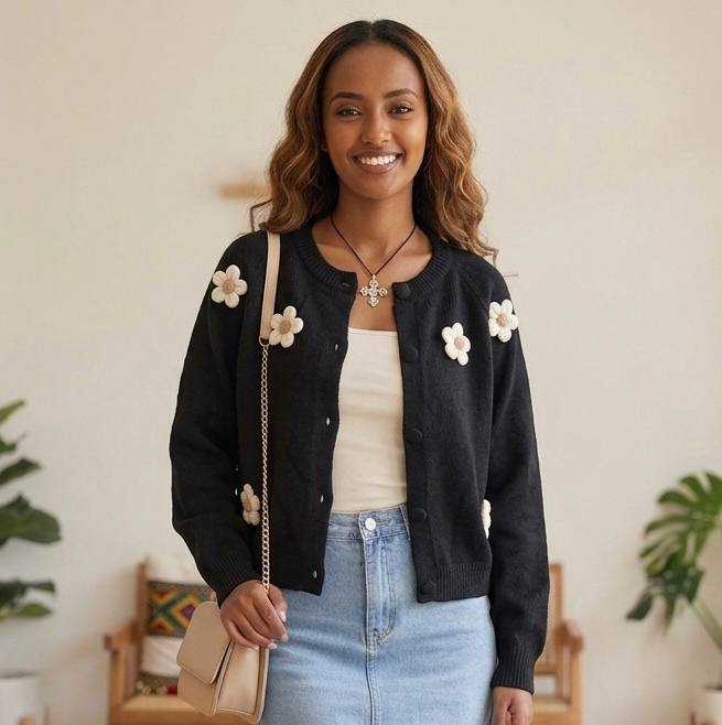 Black knit cardigan featuring 3D crochet flower applications