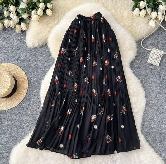 Black pleated midi or maxi skirt with a small floral and polka dot print