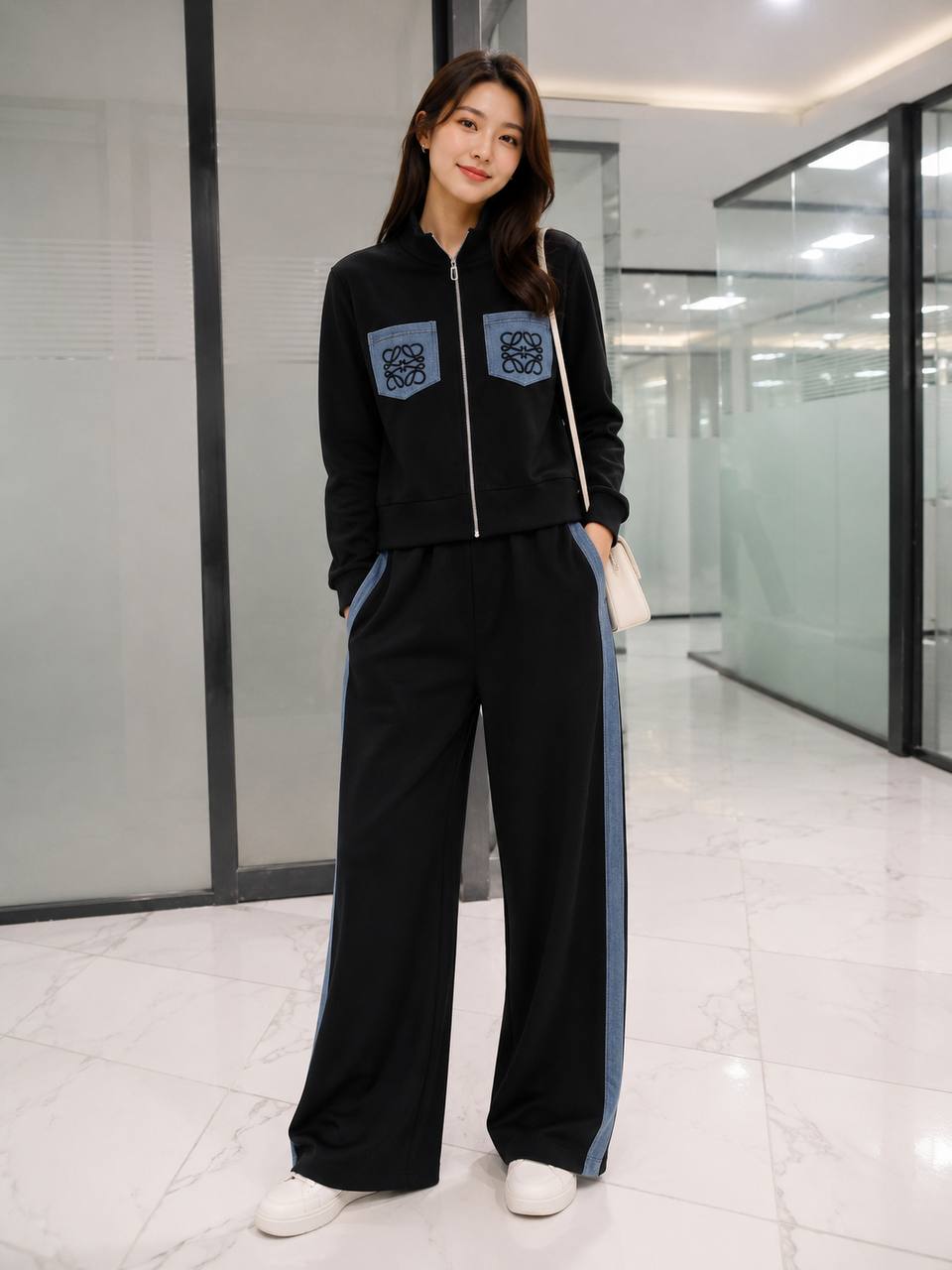 Black zip-up track jacket featuring dual blue denim patch pockets