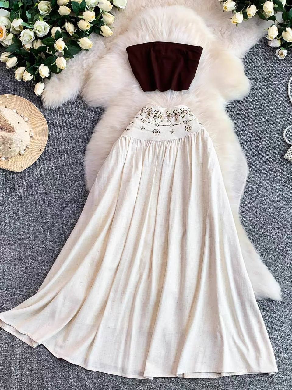 Bohemian summer outfit combines a dark brown strapless tube top with a flowing cream-colored maxi skirt